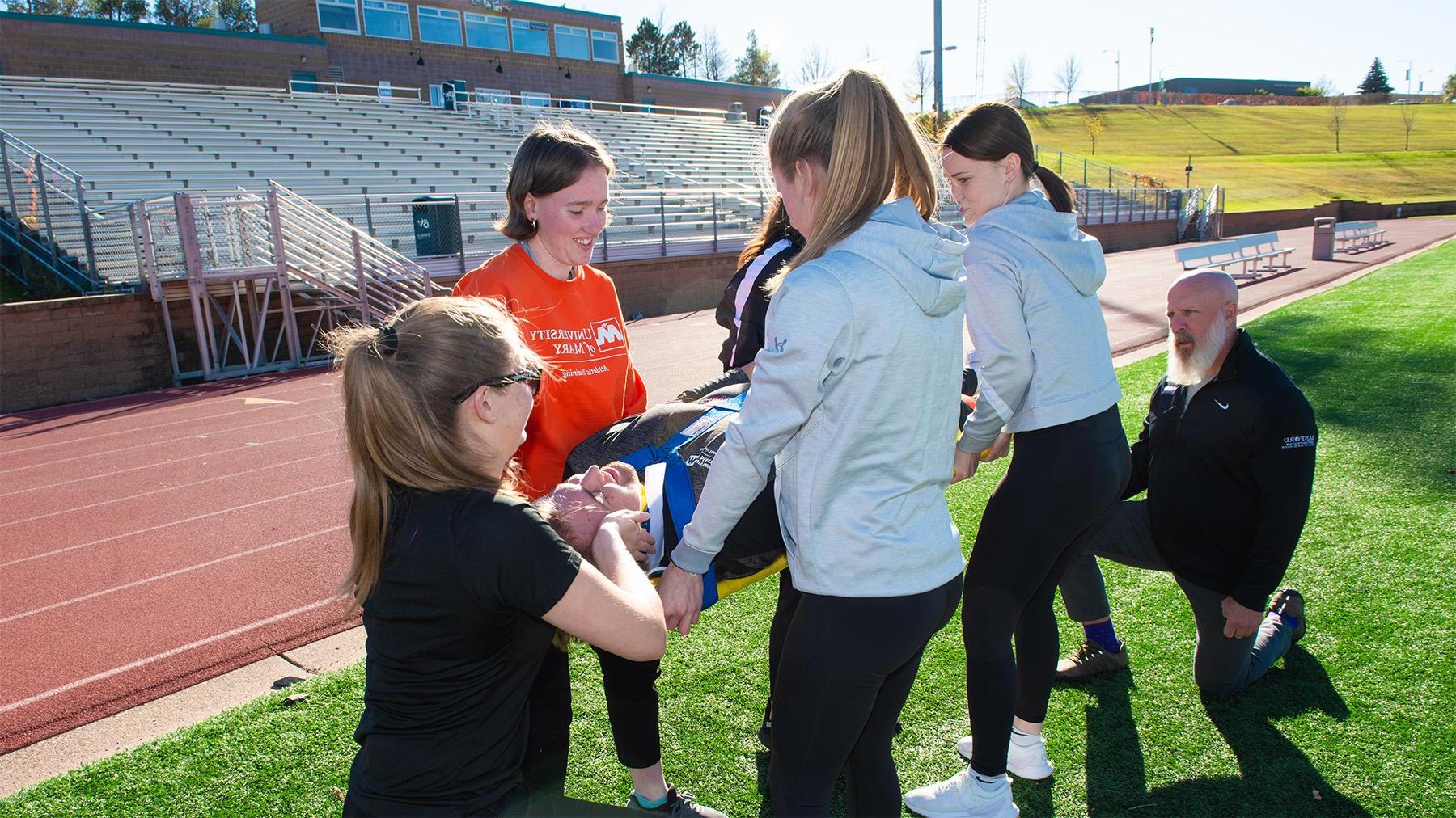 Students practicing on the football field.